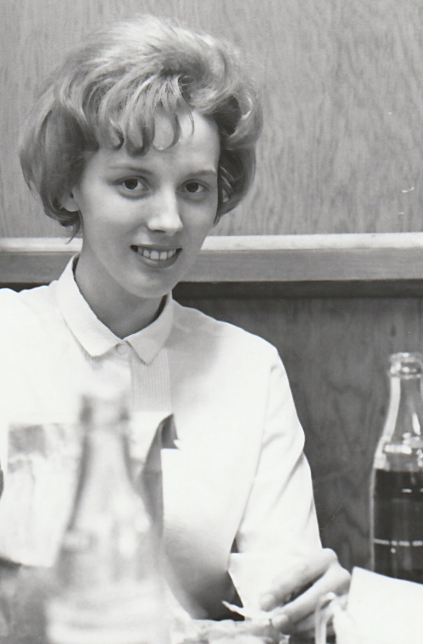 Young Sharon seated at a table
